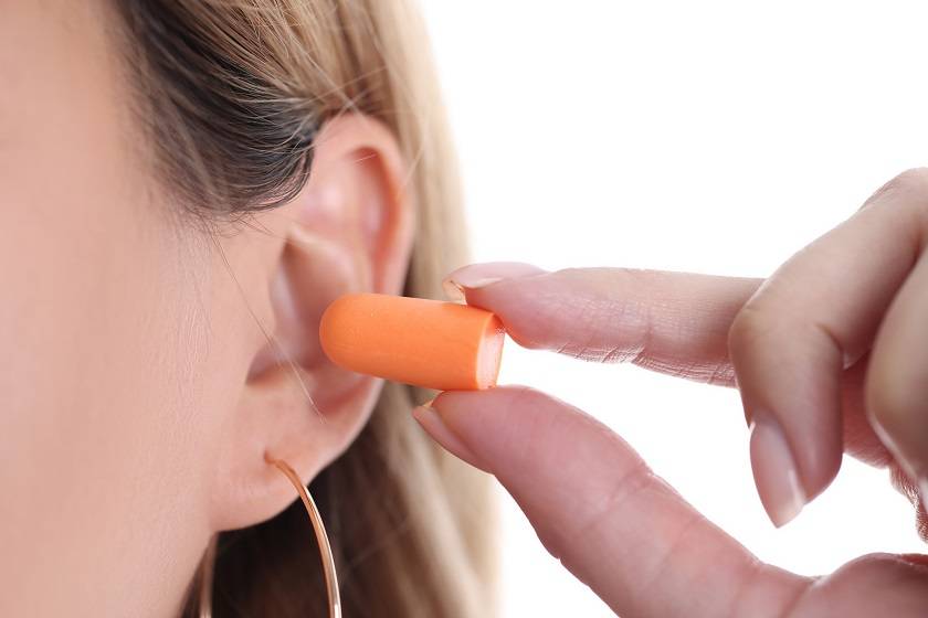 Femme mettant un bouchon d'oreilles