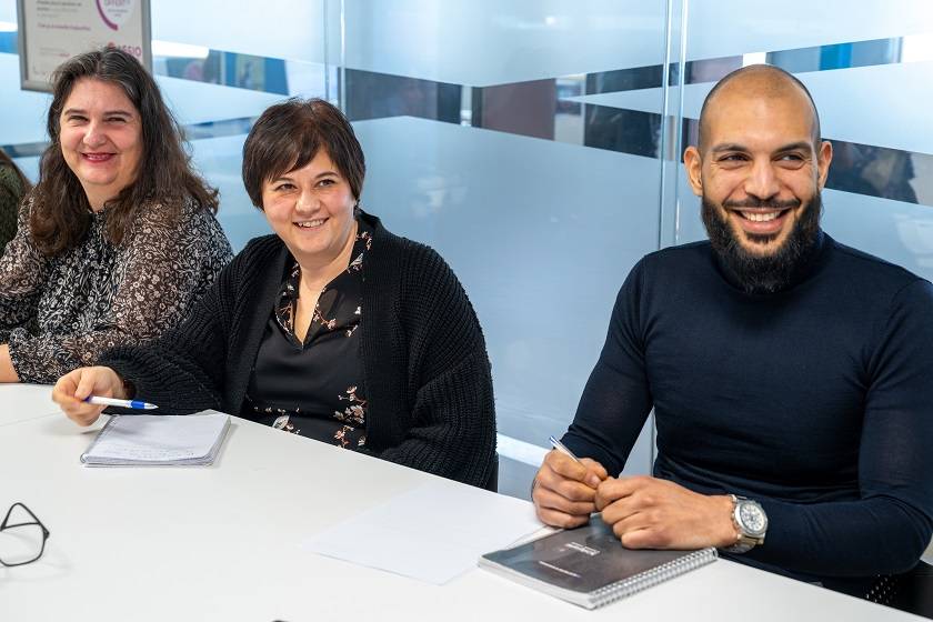 Trois personnes autour d'une table de réunion