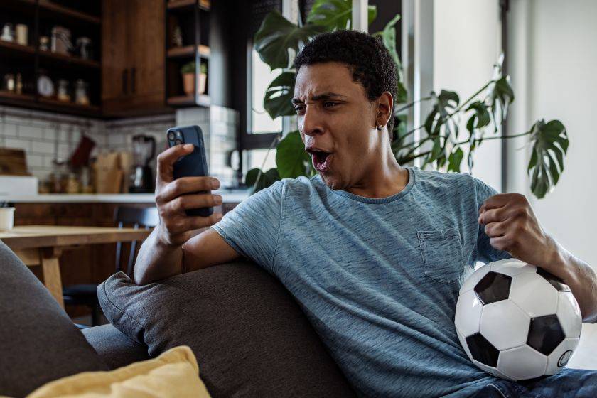 Un homme qui fait un paris sportif sur son téléphone