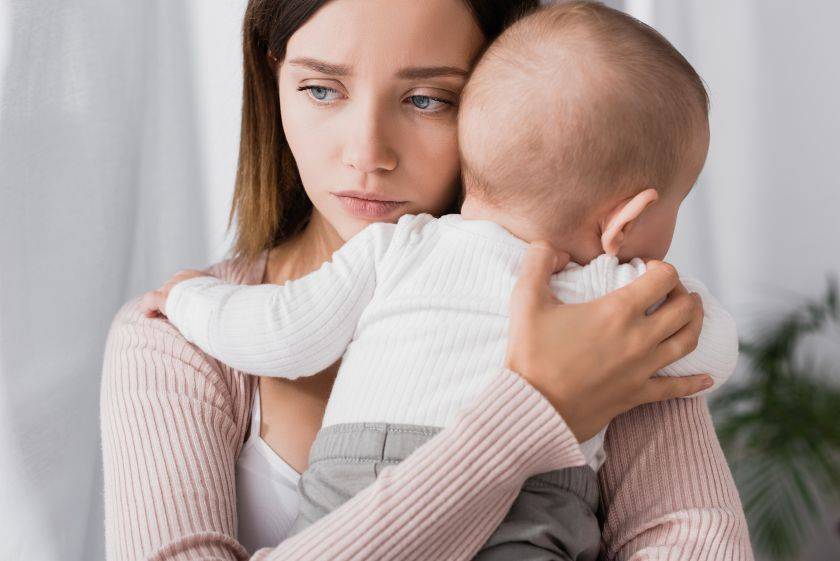 Femme qui tient son nourrisson dans les bras